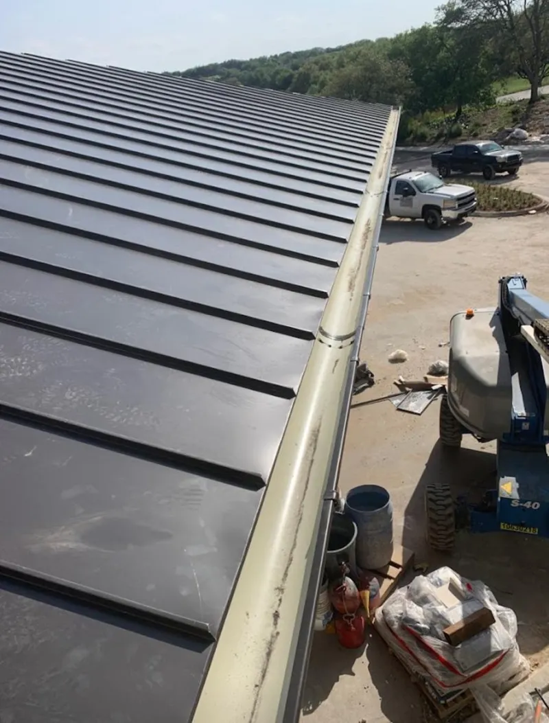 Standing seam panel and gutter detail on a metal roofing jobsite in Hudson
